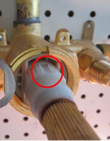 Locate the groove in the plastic cartridge body. With the groove facing up, insert the cartridge into the valve body
